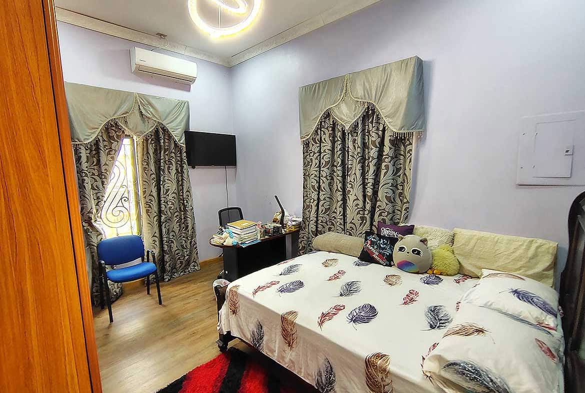 Cornerstone- Cozy bedroom with bed, curtains, and workspace in a residential retail property.