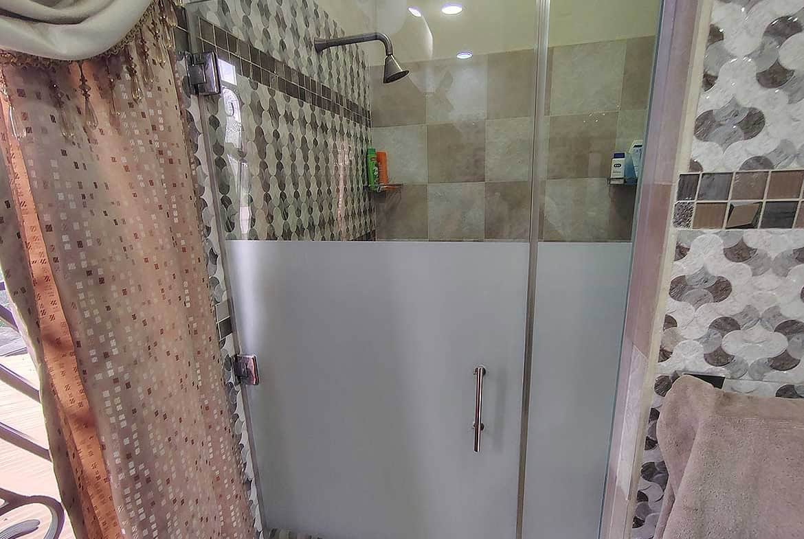 Cornerstone- Contemporary bathroom shower with glass enclosure and decorative tiles.