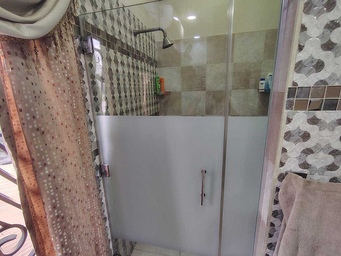 Modern Bathroom Shower Area Cornerstone- Contemporary bathroom shower with glass enclosure and decorative tiles.