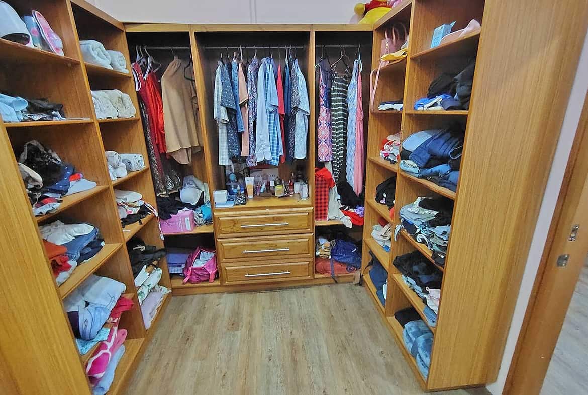 Cornerstone- Large walk-in closet with organized shelves and hanging space for clothes and accessories.