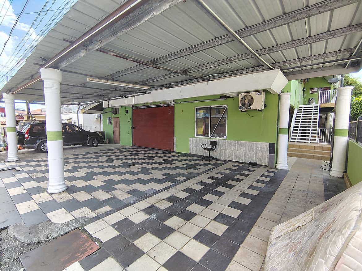 Cornerstone™ Ganga Terrace El Socorro Cornerstone- Covered parking area at Ganga Terrace in El Socorro with green walls and checkered floor.