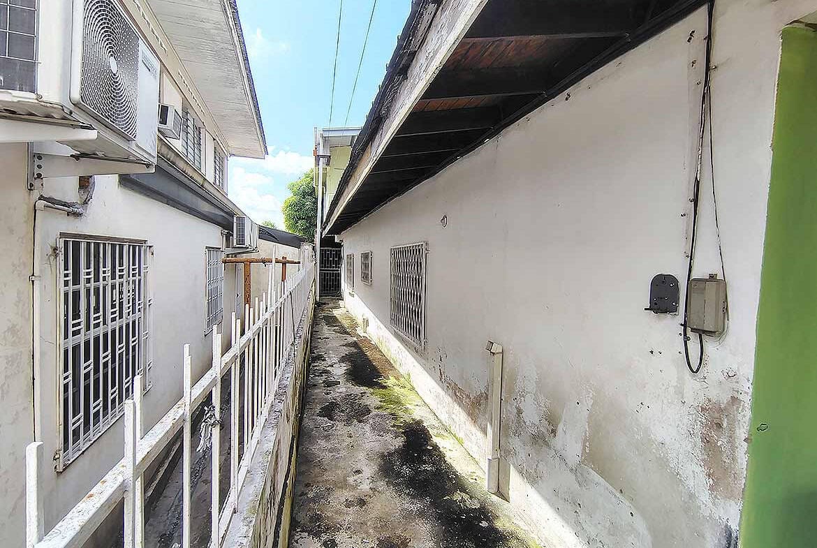 Cornerstone- Narrow alleyway between buildings in Ganga Terrace, El Socorro.