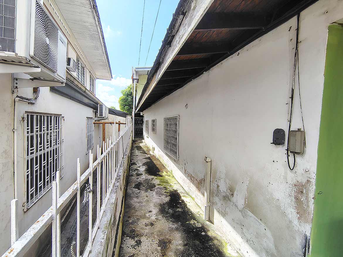Ganga Terrace Alleyway Cornerstone- Narrow alleyway between buildings in Ganga Terrace, El Socorro.