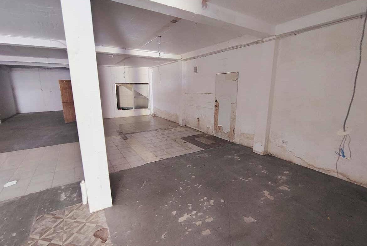 Cornerstone- Empty commercial space with white walls and concrete floor at Ganga Terrace.