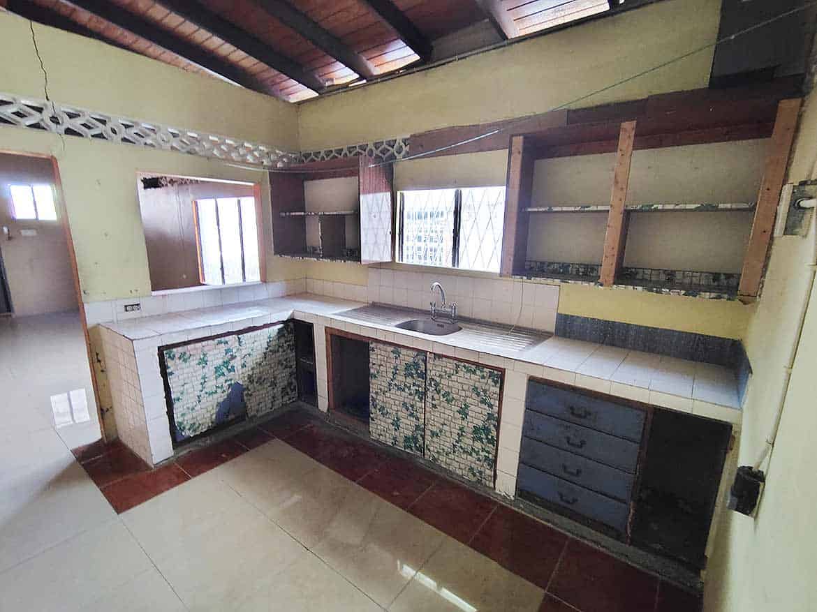 Kitchen Renovation at Ganga Terrace Cornerstone- Renovated kitchen with tiled cabinets and wooden shelves at Ganga Terrace.