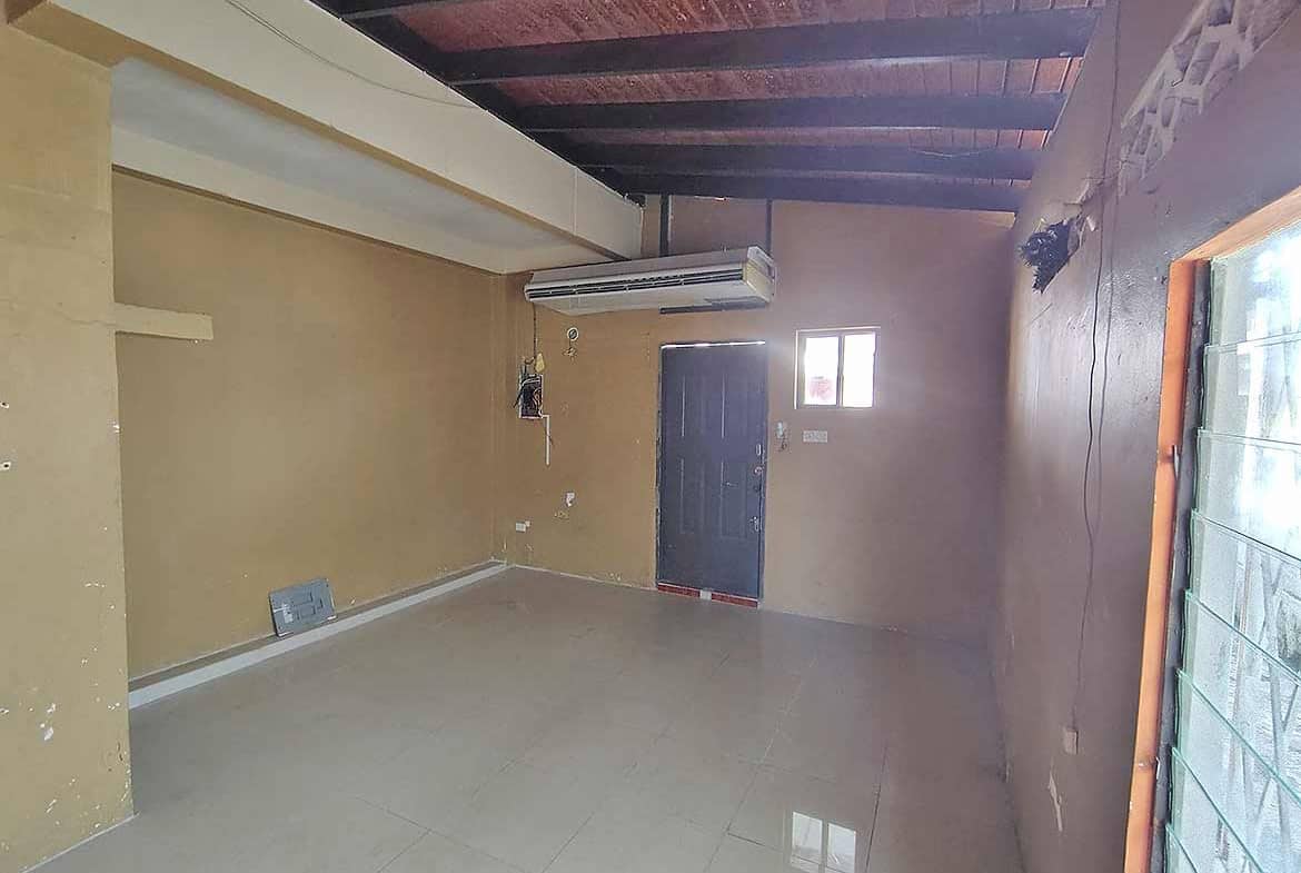 Cornerstone- Spacious room with high wooden ceiling and air conditioning unit.