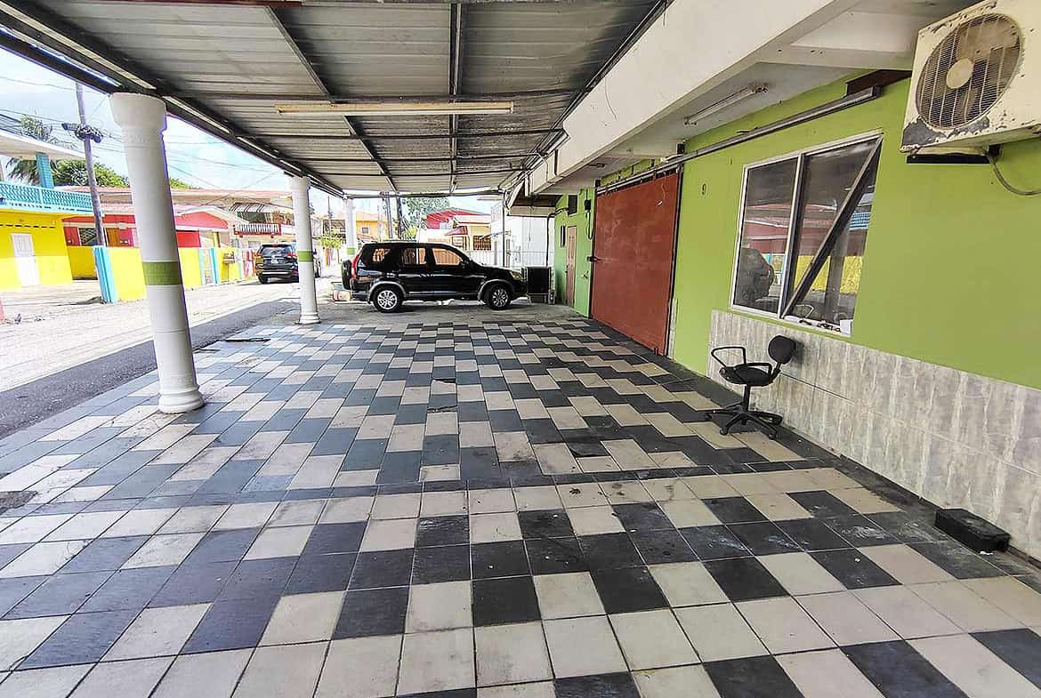 Cornerstone- Covered parking area at Ganga Terrace, El Socorro with colorful buildings nearby.