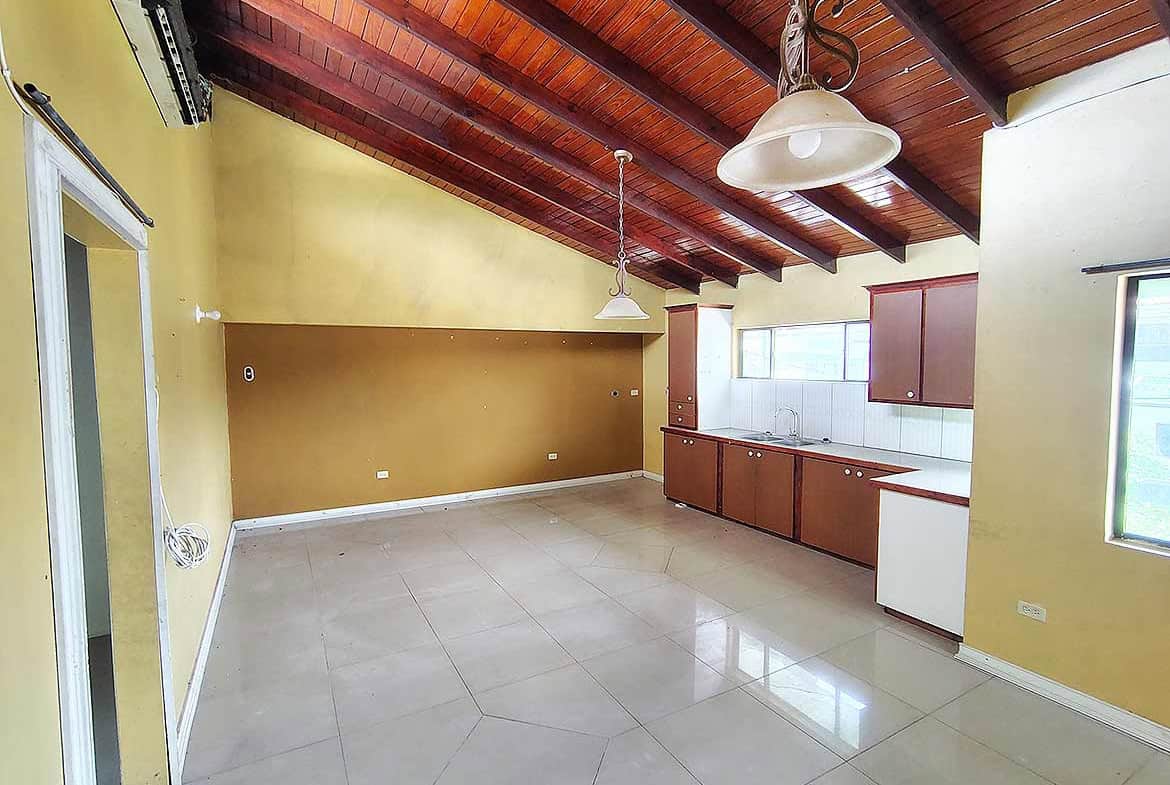 Cornerstone- Bright, open kitchen with wooden ceiling and modern fixtures at Ganga Terrace.