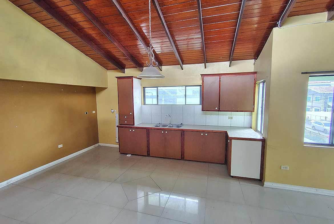 Cornerstone- Bright kitchen with wooden ceiling and large windows at Ganga Terrace.