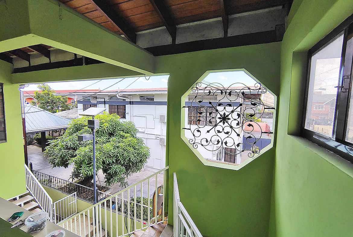 Cornerstone- Balcony view with green walls and decorative window at Ganga Terrace.