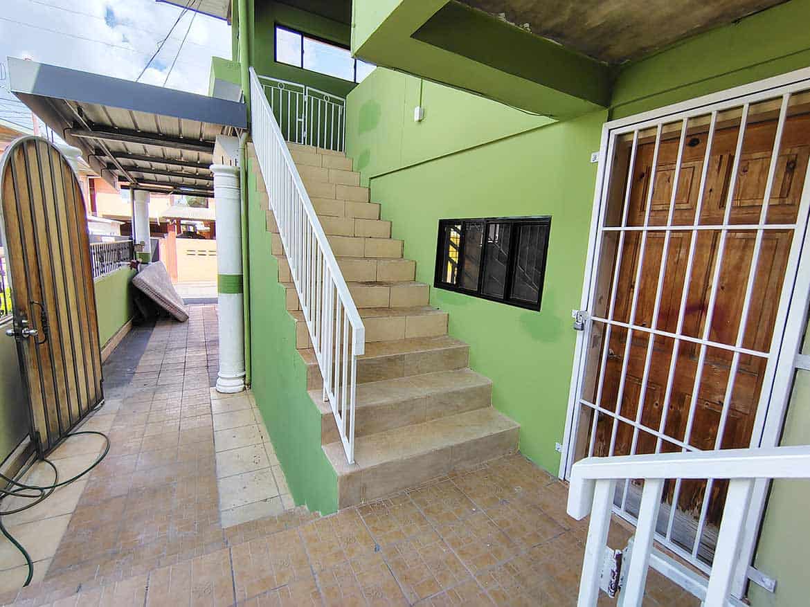 Exterior Staircase at Ganga Terrace Cornerstone- Green building exterior with staircase and sliding door at Ganga Terrace.