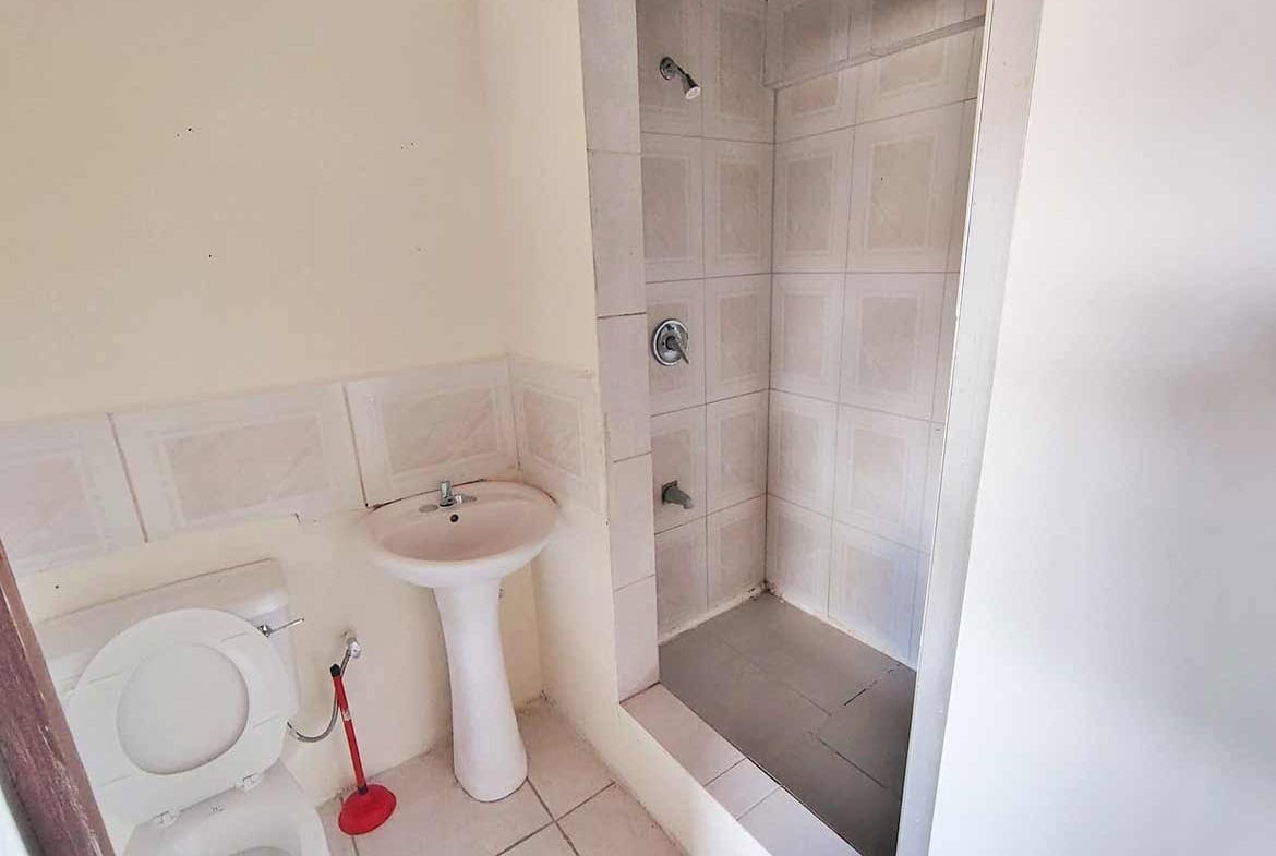 Cornerstone- Clean bathroom with shower, sink, and toilet in a residential space.