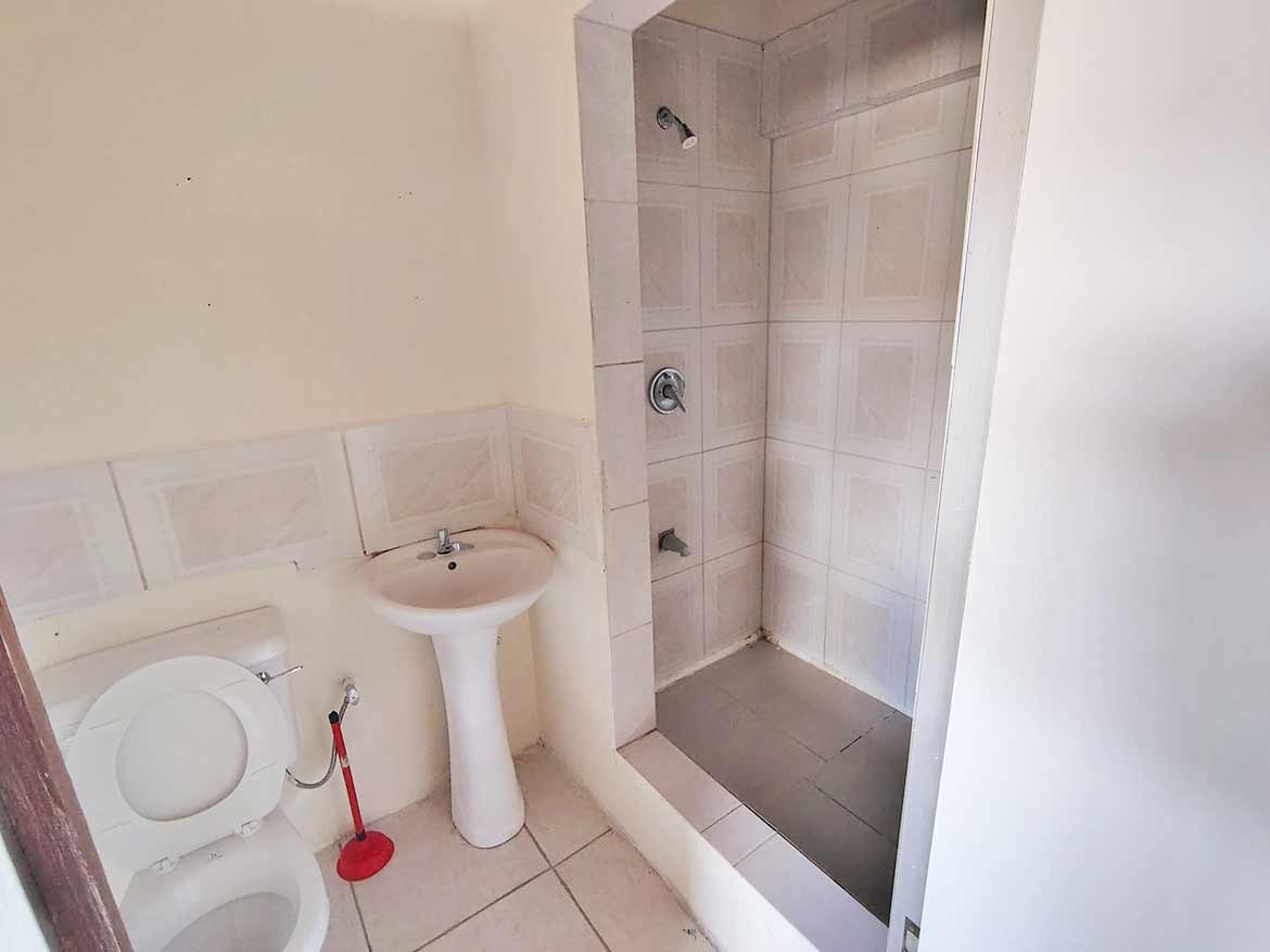 Modern Bathroom Shower and Sink Cornerstone- Clean bathroom with shower, sink, and toilet in a residential space.