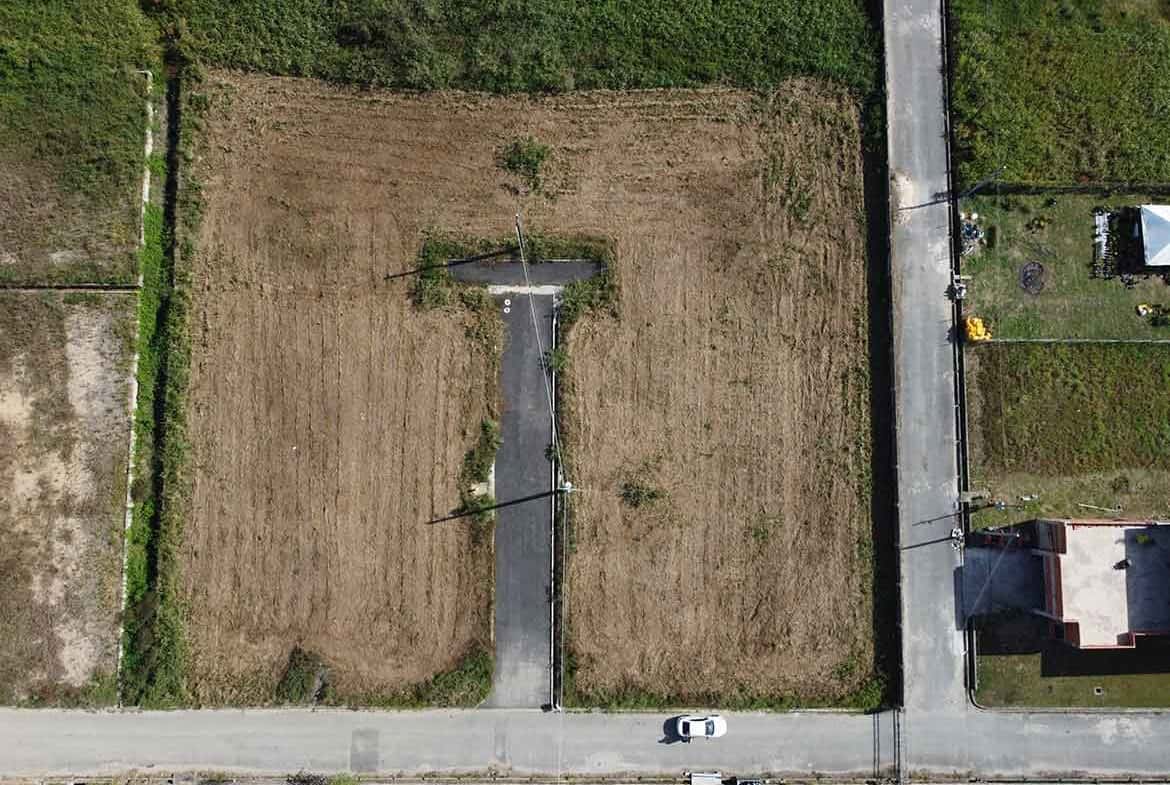 Cornerstone- Empty plot of land on St Louis Dr, Longdenville with a small tree and paved pathway.
