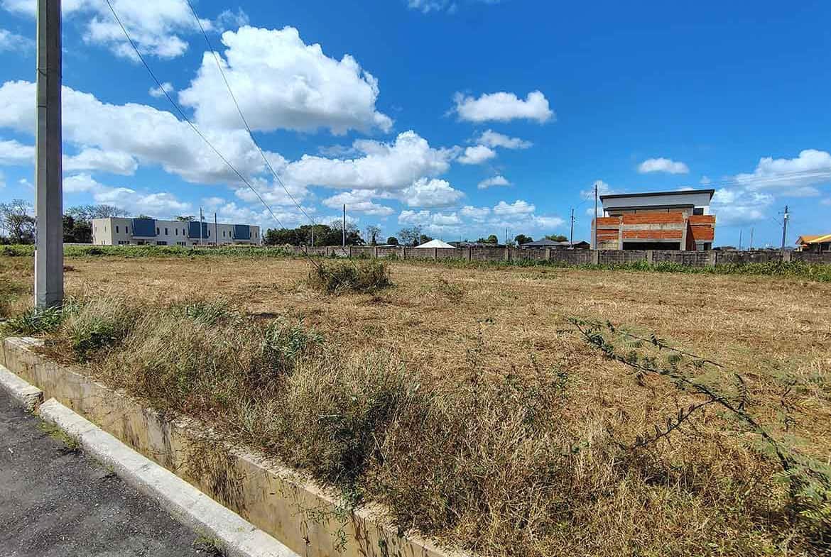 Cornerstone- Open grassy land with buildings in the background near St Louis Dr, Longdenville.
