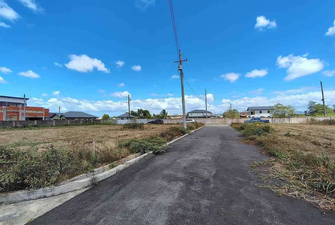 Cornerstone- Newly paved street in Longdenville with utility poles and houses in the background.
