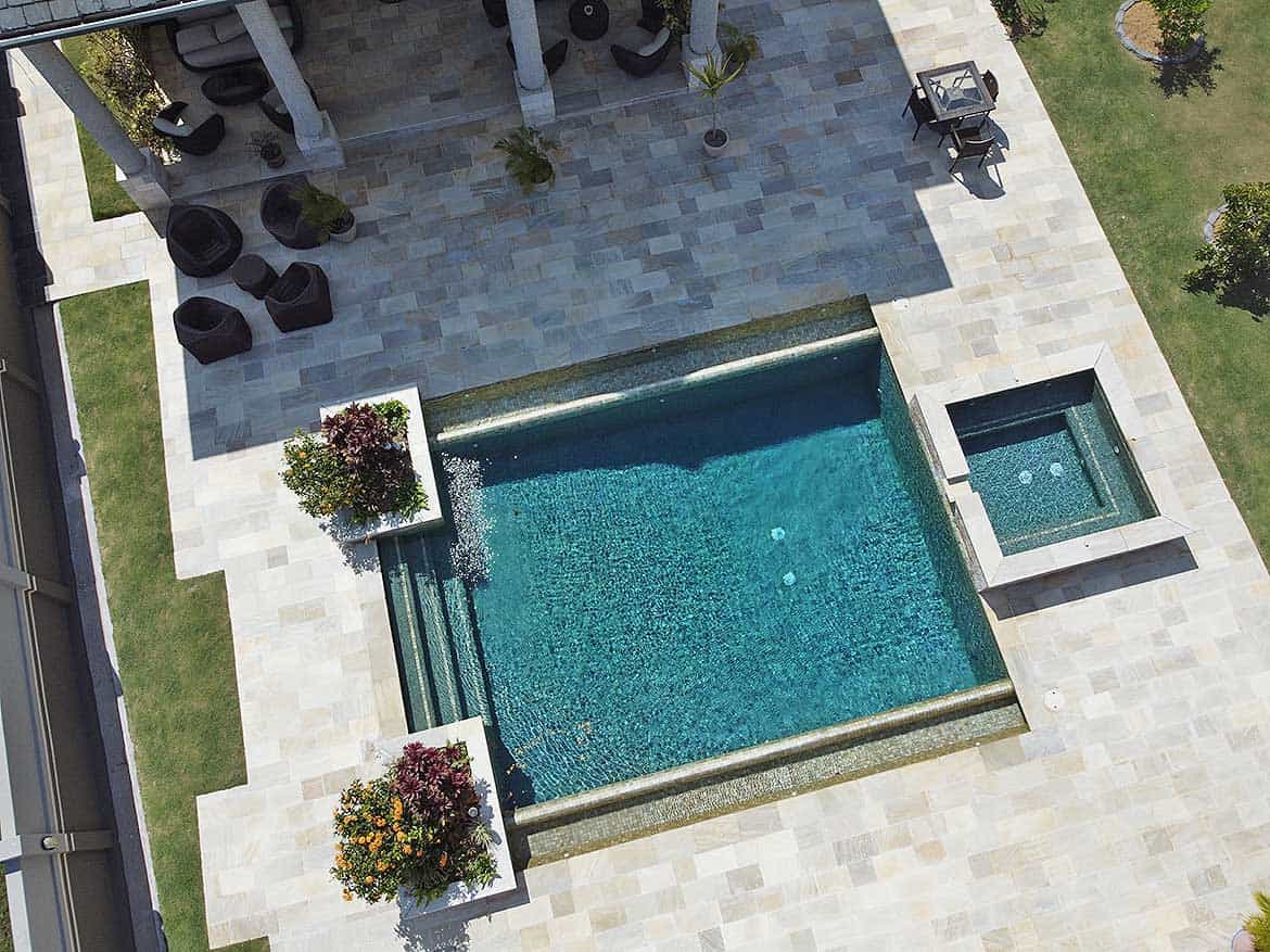 Millennium Lakes Home Pool Area Cornerstone- Aerial view of a modern backyard pool with hot tub and outdoor seating.
