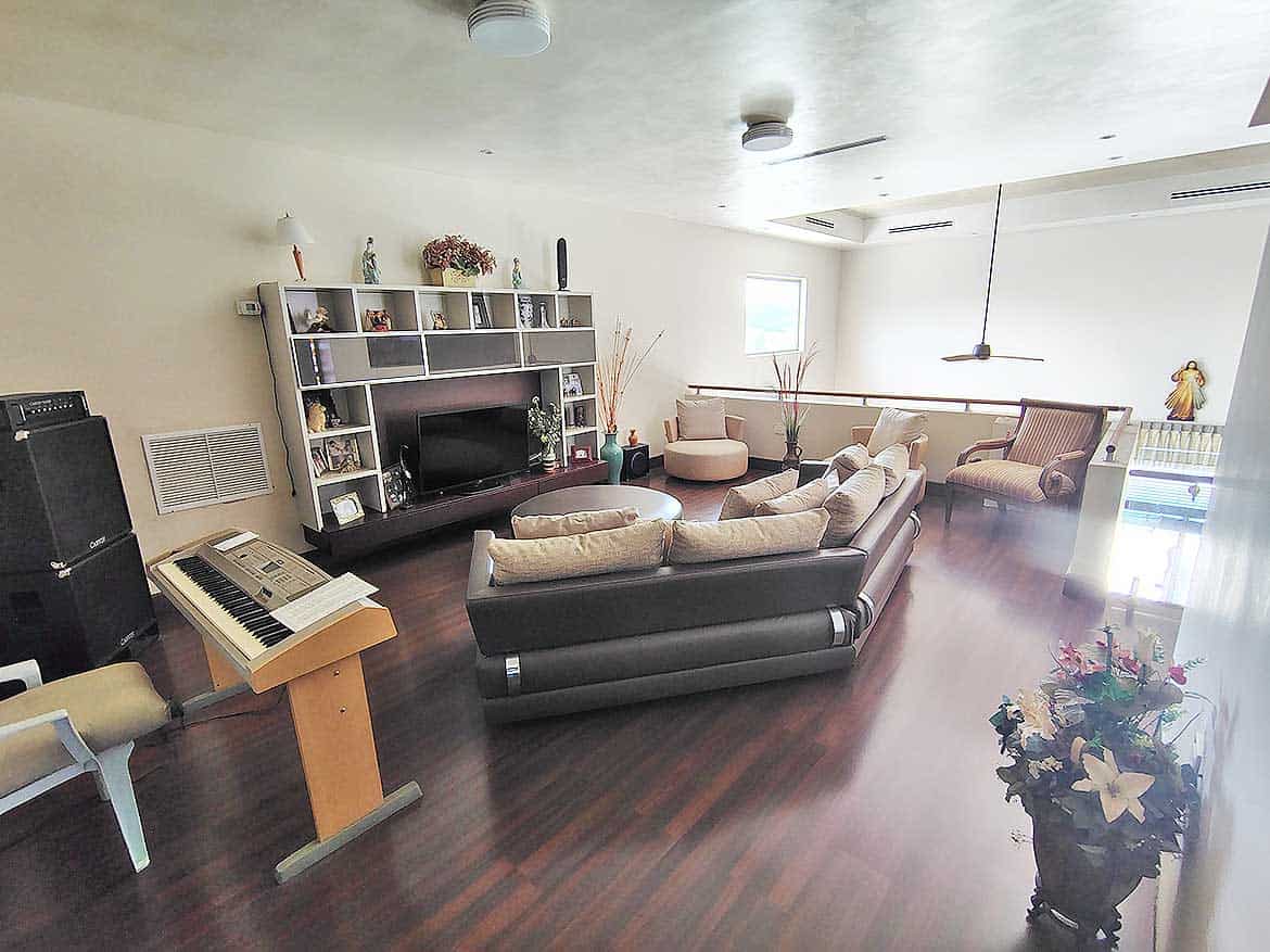 Spacious Living Room at Millennium Lakes Home Cornerstone- Bright, modern living room with comfortable seating and entertainment center.