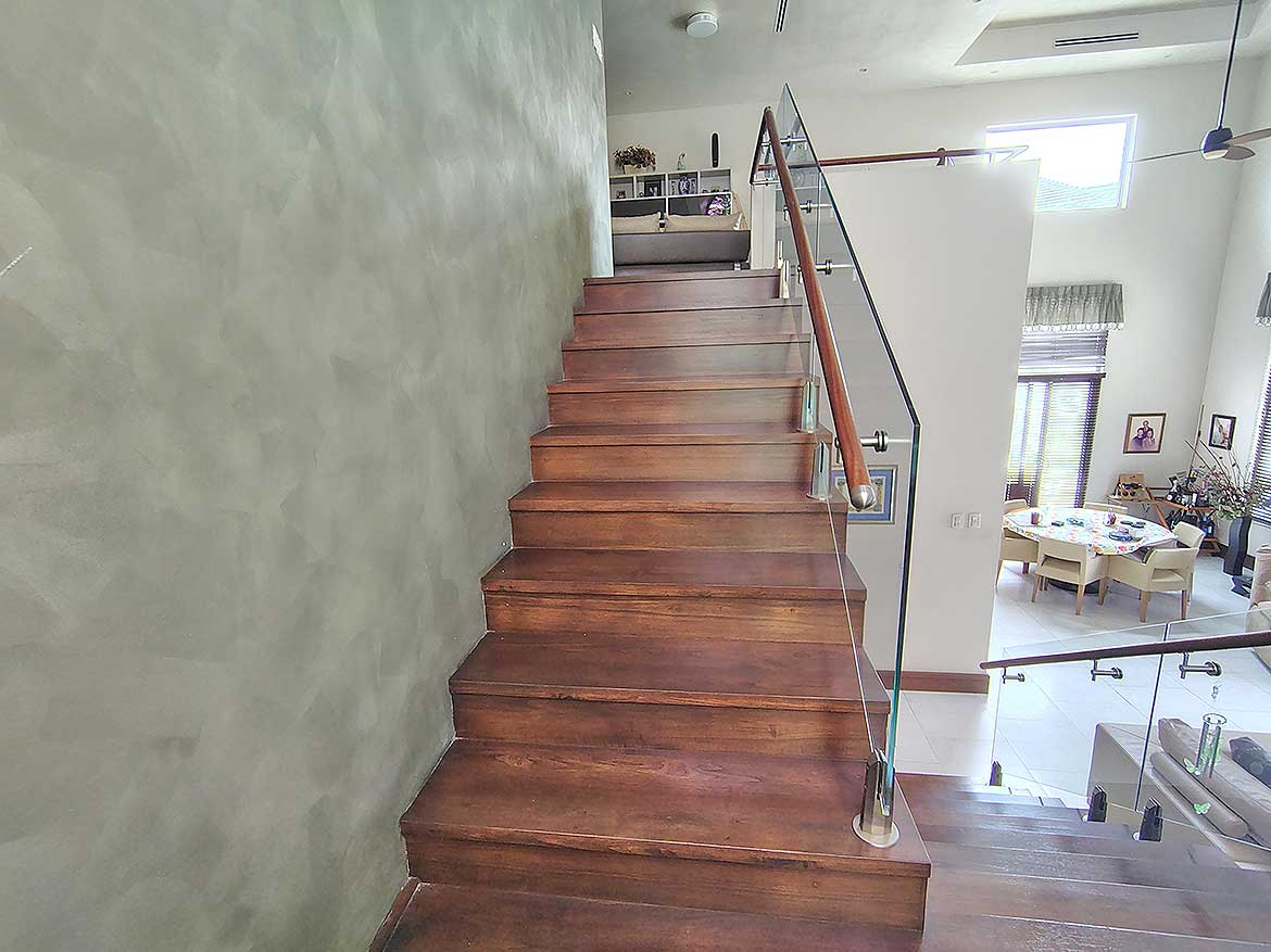 Modern Wooden Staircase at Millennium Lakes Home Cornerstone- Elegant wooden staircase with glass railing in contemporary home interior.