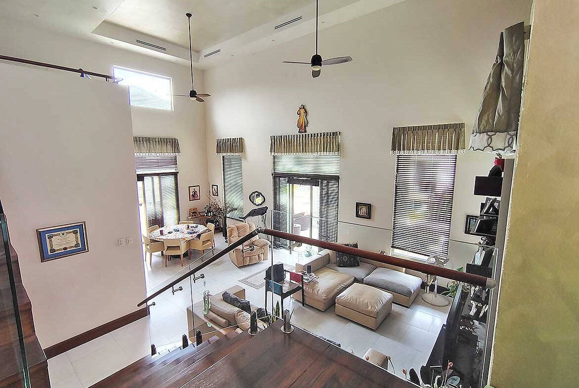 Cornerstone- Bright, modern living room with high ceilings and large windows.