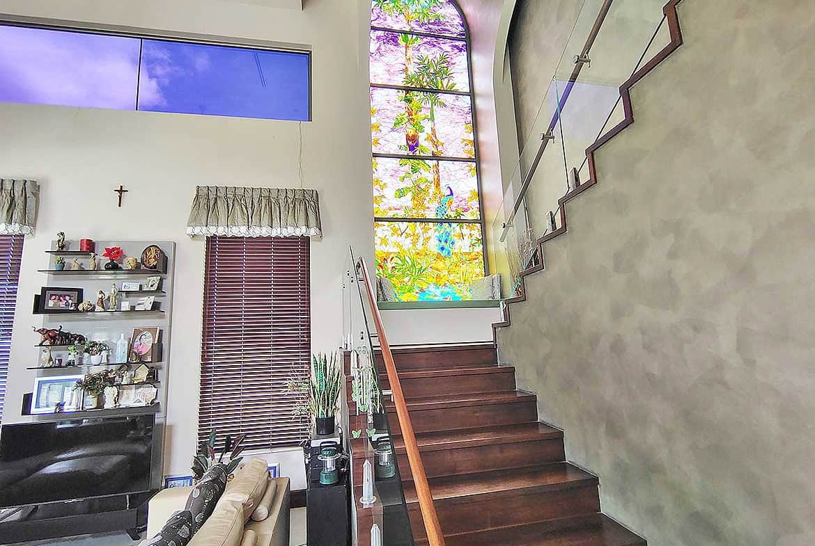 Cornerstone- Interior staircase with large stained glass window and modern decor.