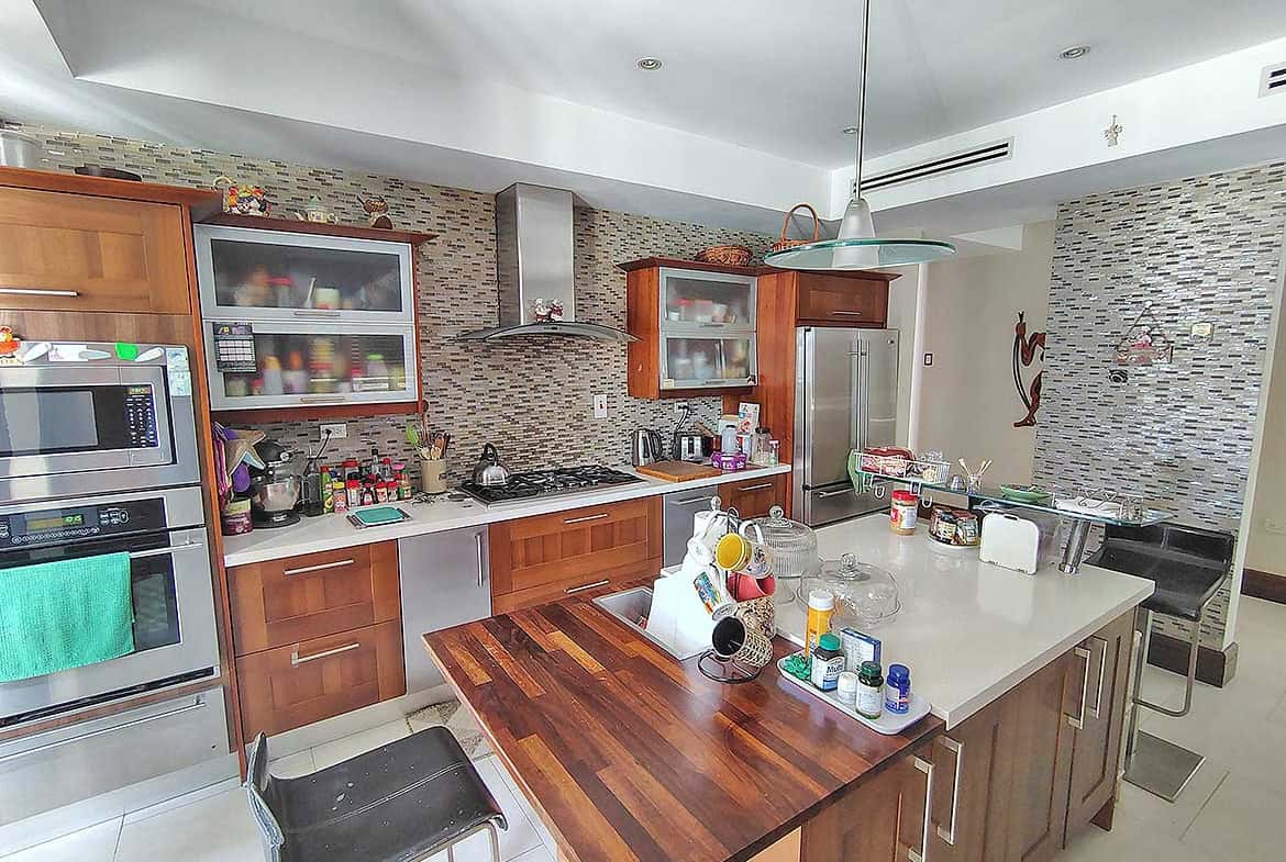 Cornerstone- Contemporary kitchen with wooden cabinets, stainless steel appliances, and a large island.