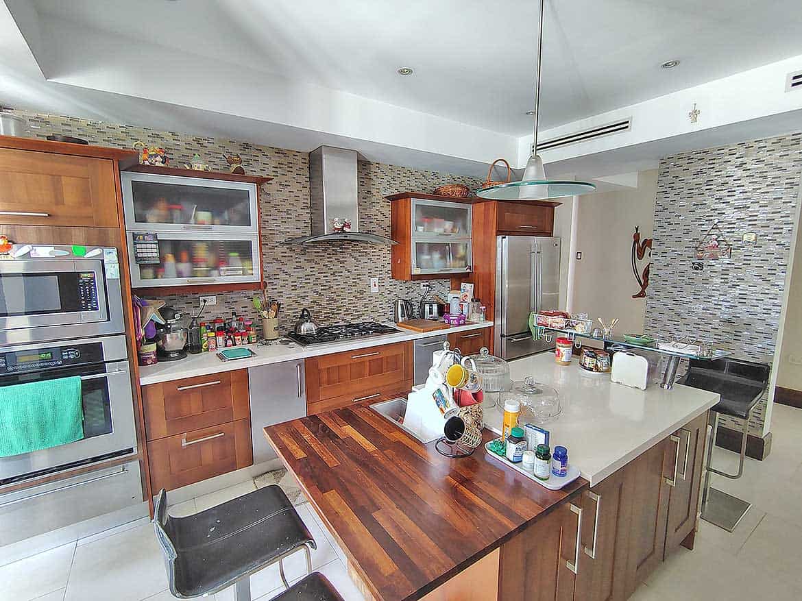 Modern Kitchen with Wooden Cabinets Cornerstone- Contemporary kitchen with wooden cabinets, stainless steel appliances, and a large island.