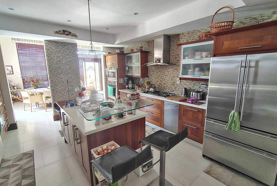 Cornerstone- Spacious modern kitchen with stainless steel appliances and island.