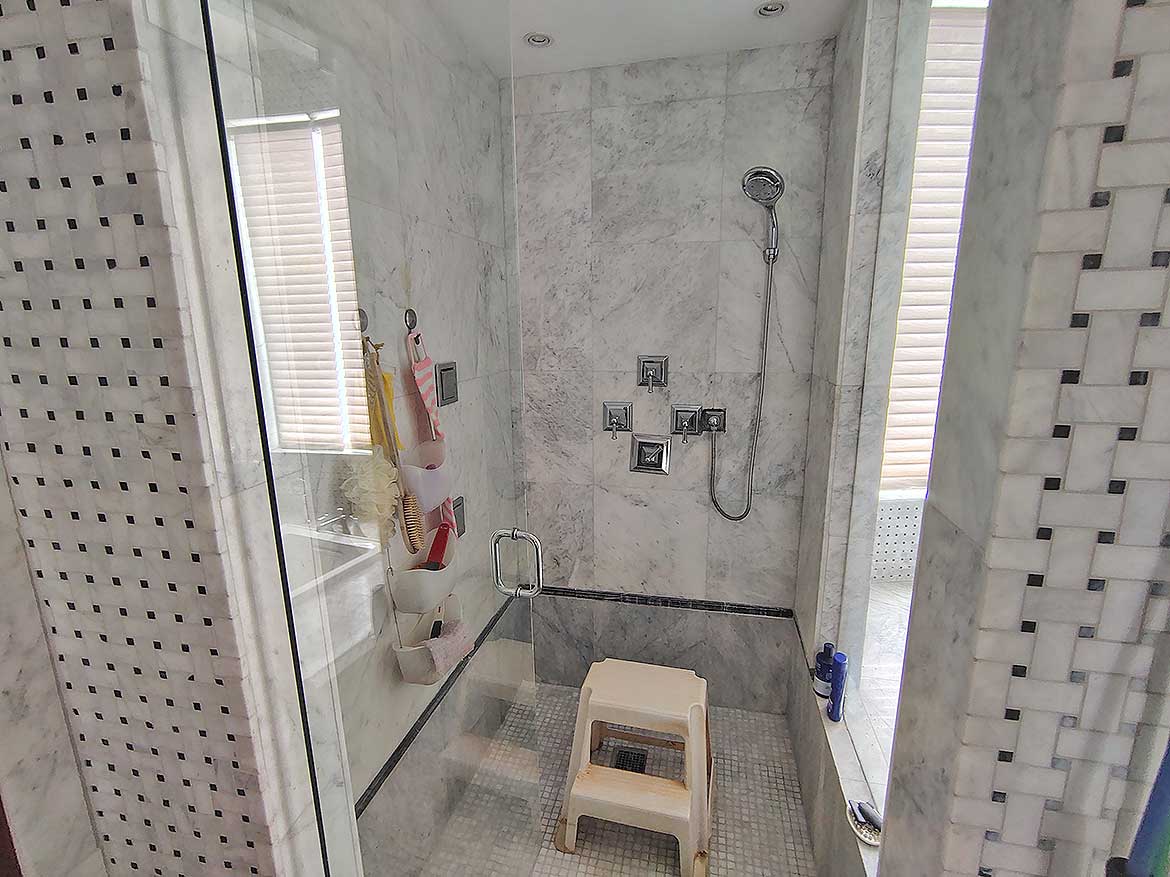 Modern Walk-In Shower at Millennium Lakes Home Cornerstone- Contemporary walk-in shower with marble tiles and glass enclosure at Millennium Lakes Home.