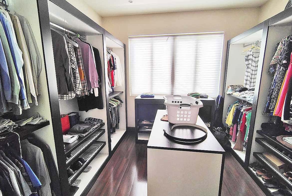Cornerstone- Spacious walk-in closet with organized clothing and accessories.