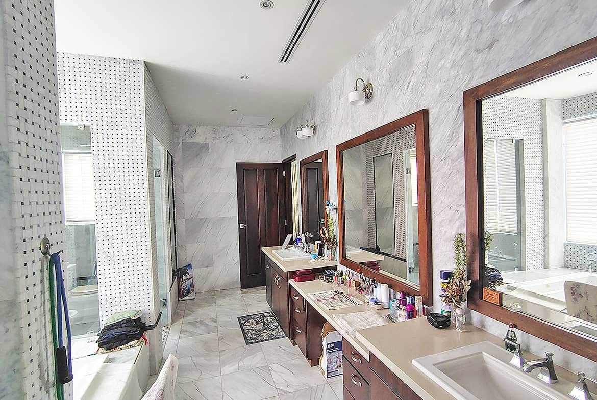 Cornerstone- Elegant bathroom with dual sinks, large mirrors, and modern fixtures at Millennium Lakes Home.