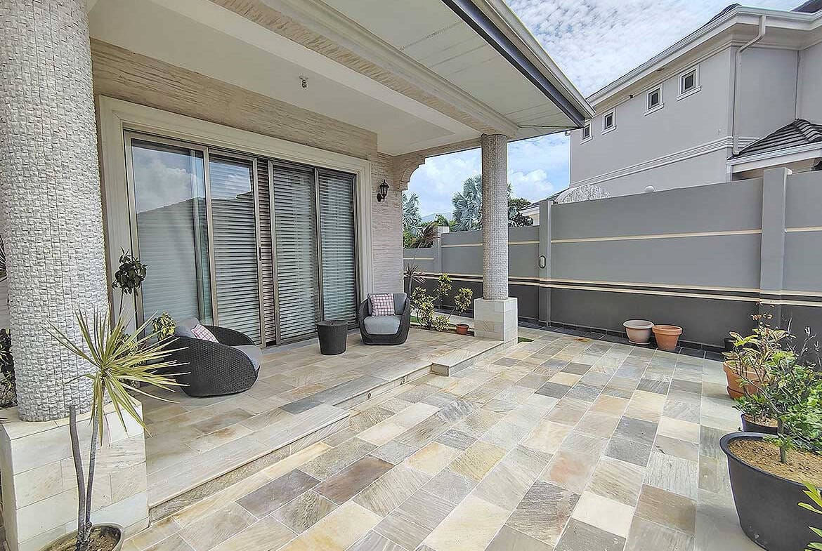 Cornerstone- Spacious outdoor patio at Millennium Lakes Home with seating and potted plants.