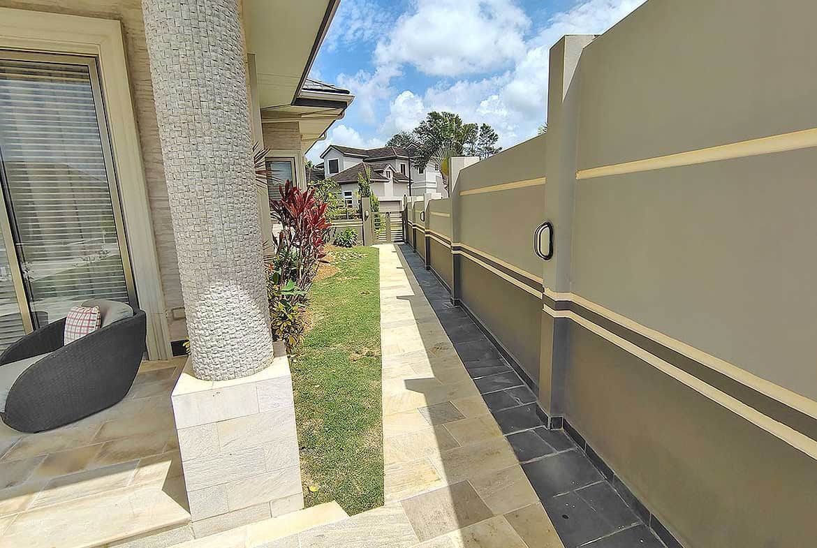 Cornerstone- Residential backyard with privacy wall, garden, and outdoor seating area.