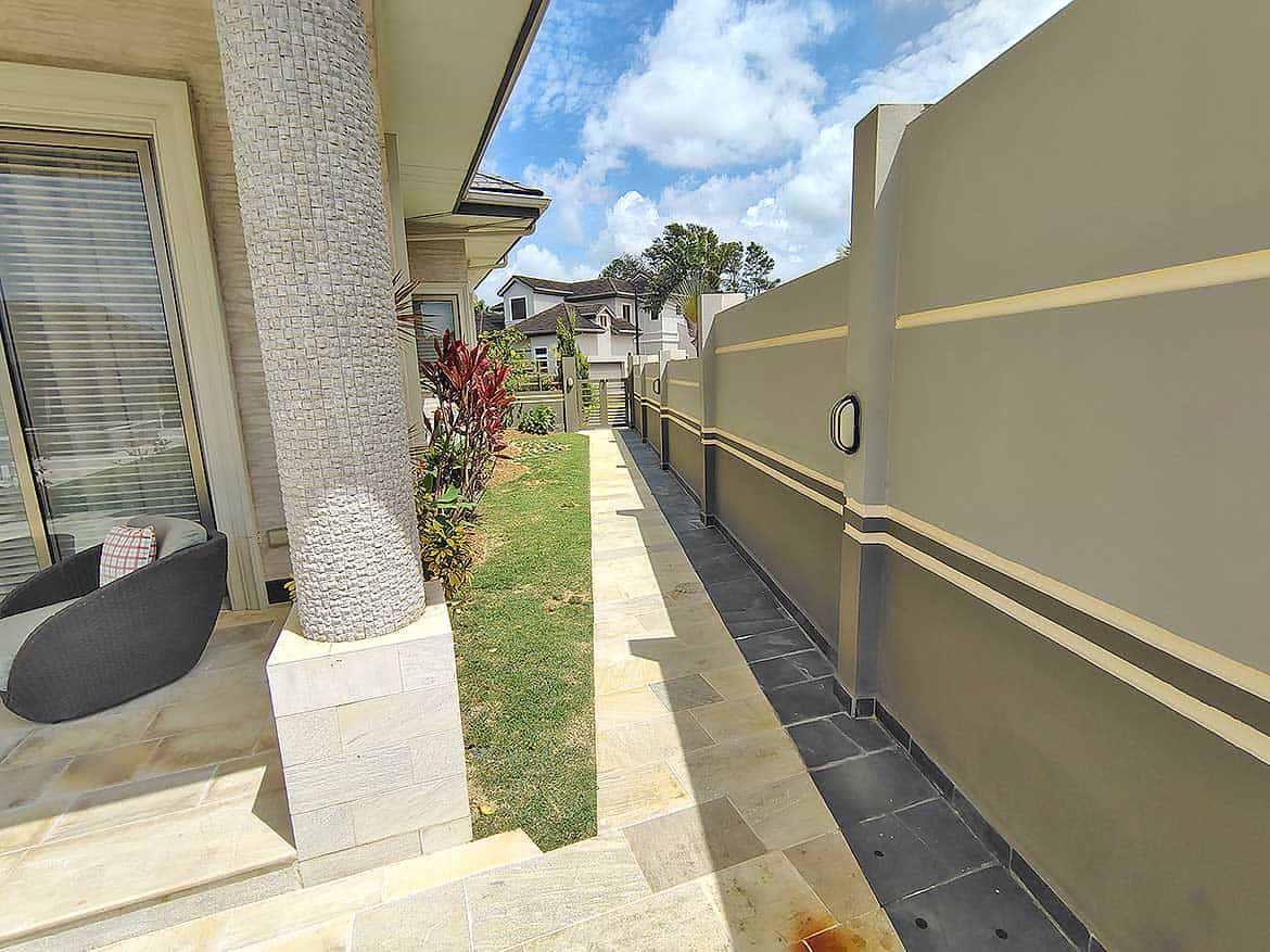 Modern residential backyard with privacy wall Cornerstone- Residential backyard with privacy wall, garden, and outdoor seating area.
