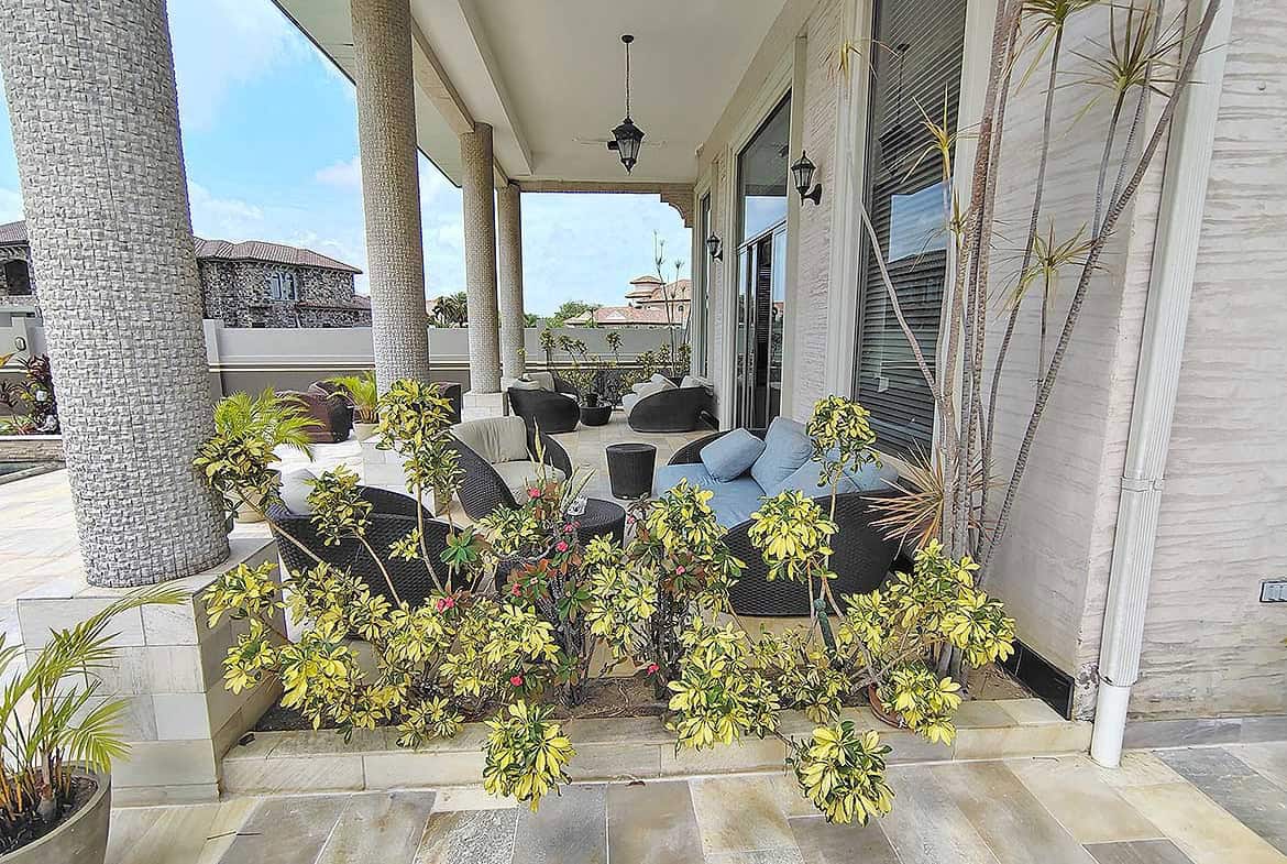 Cornerstone- Elegant porch with outdoor seating and lush plants at Millennium Lakes Home.