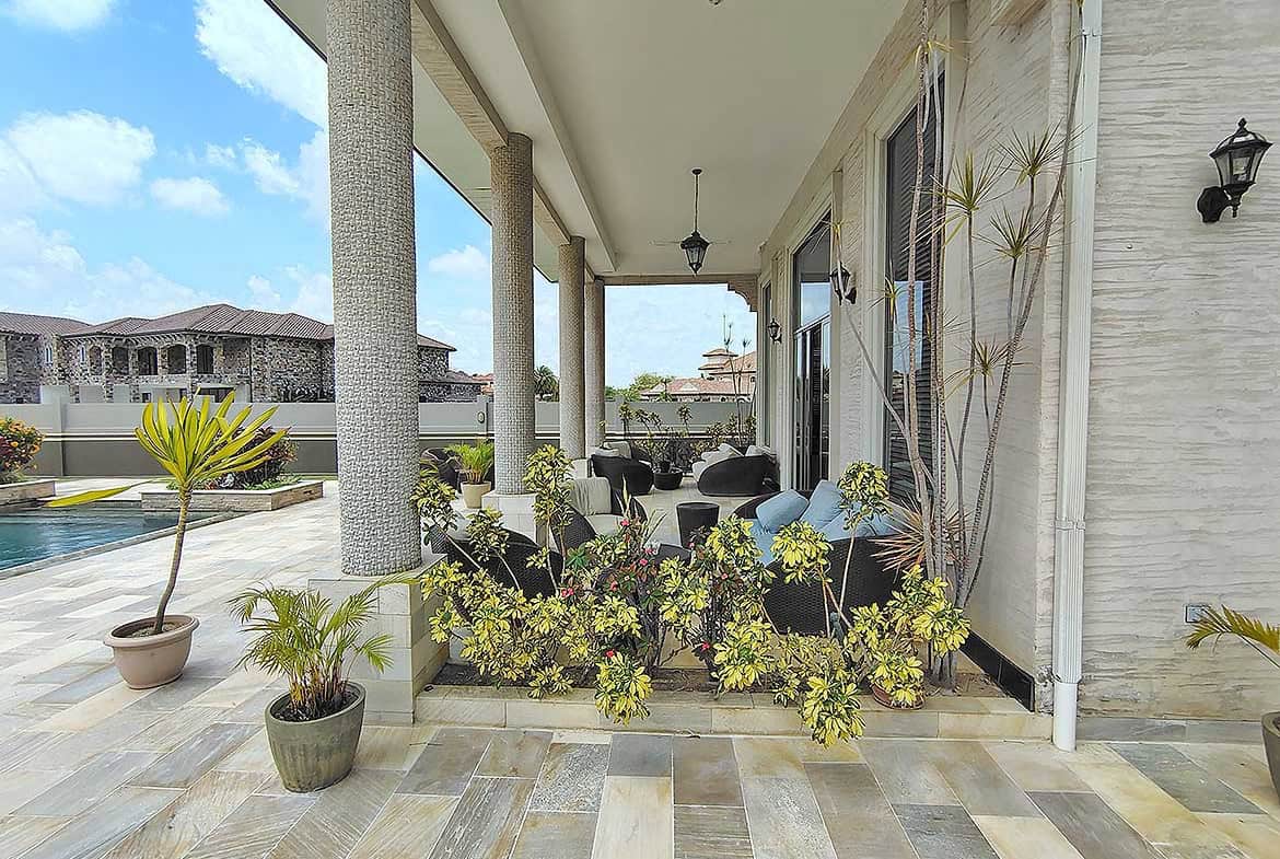 Cornerstone- Elegant porch with potted plants and outdoor seating at Millennium Lakes Home.