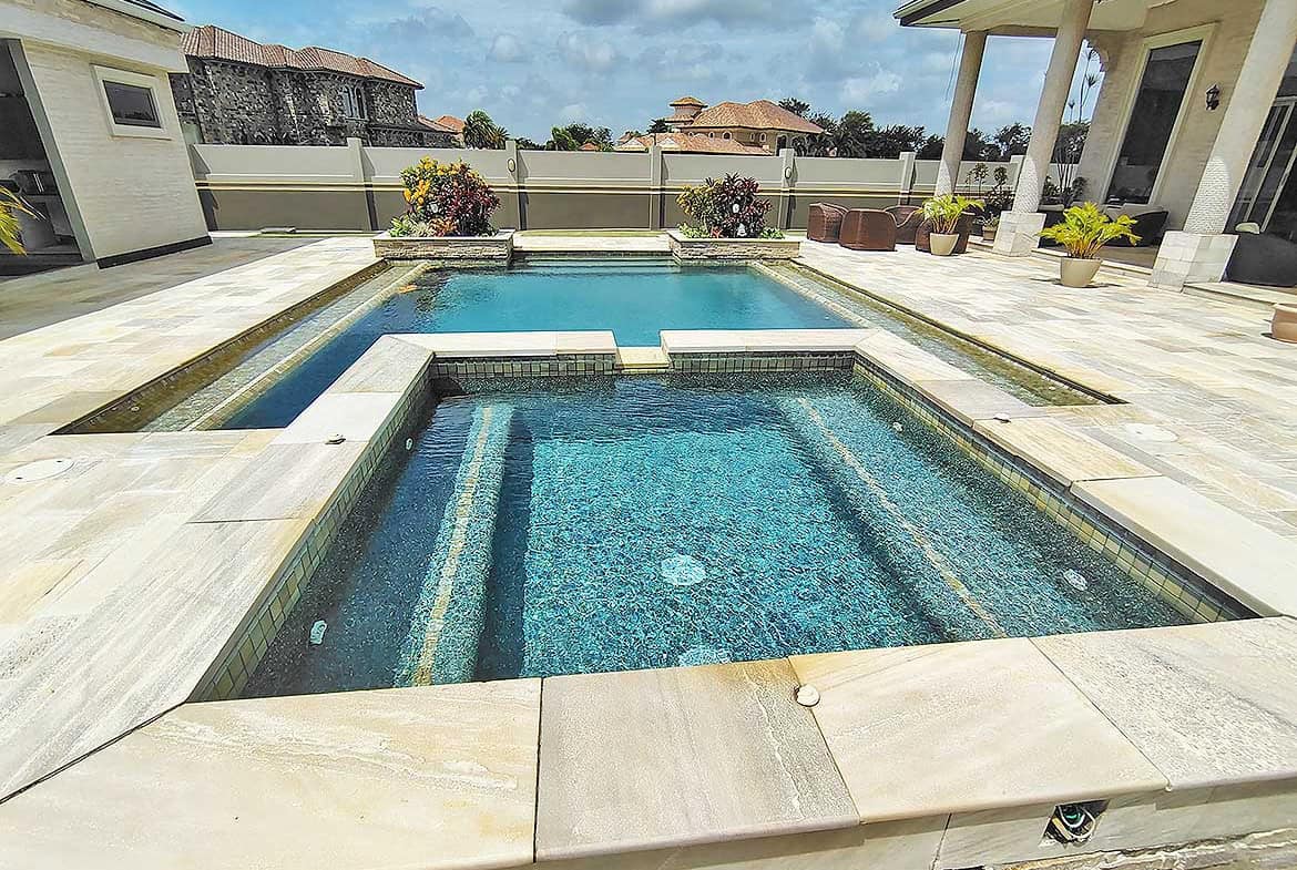 Cornerstone- Modern backyard pool with hot tub and spacious patio area.