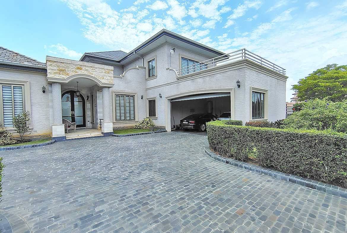 Cornerstone- Elegant modern house with spacious driveway and lush landscaping.