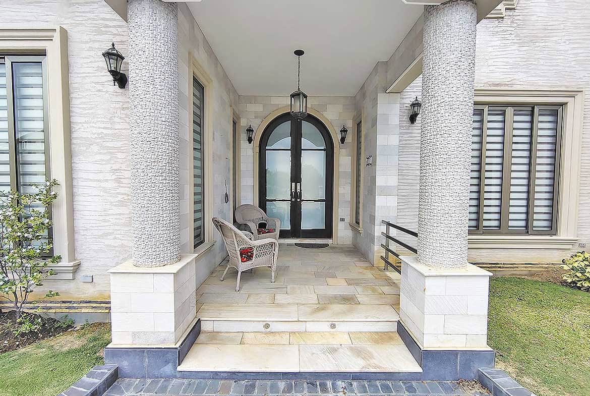 Cornerstone- Elegant home entrance with columns and seating area at Millennium Lakes.