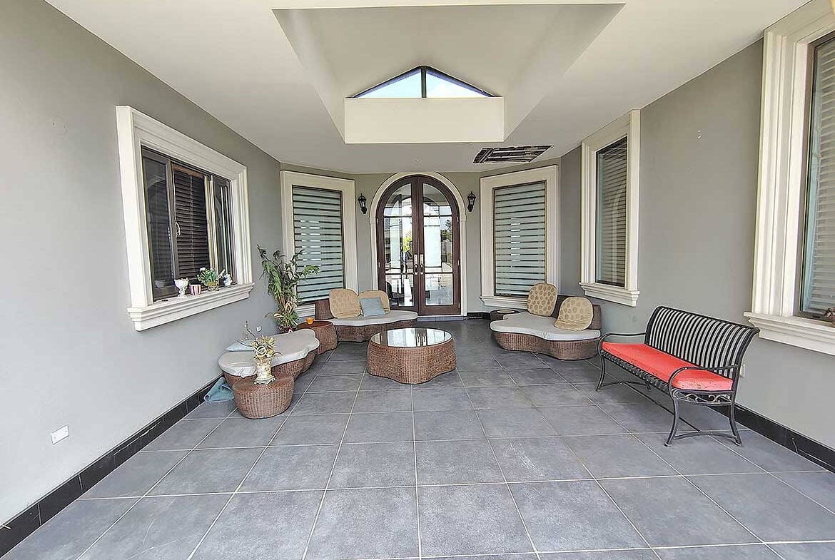 Cornerstone- Bright sunroom with large windows and comfortable seating at Millennium Lakes Home.