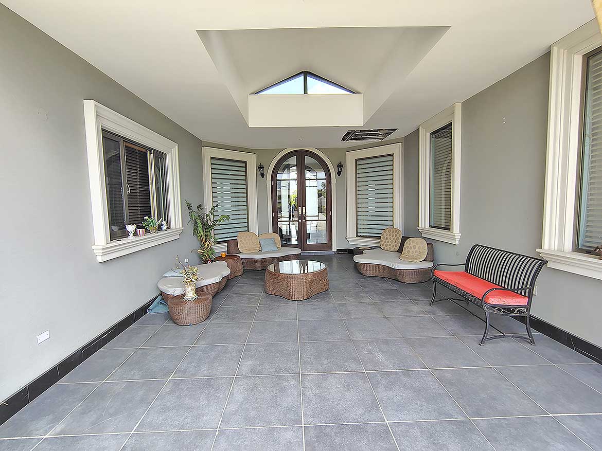 Spacious Sunroom at Millennium Lakes Home Cornerstone- Bright sunroom with large windows and comfortable seating at Millennium Lakes Home.