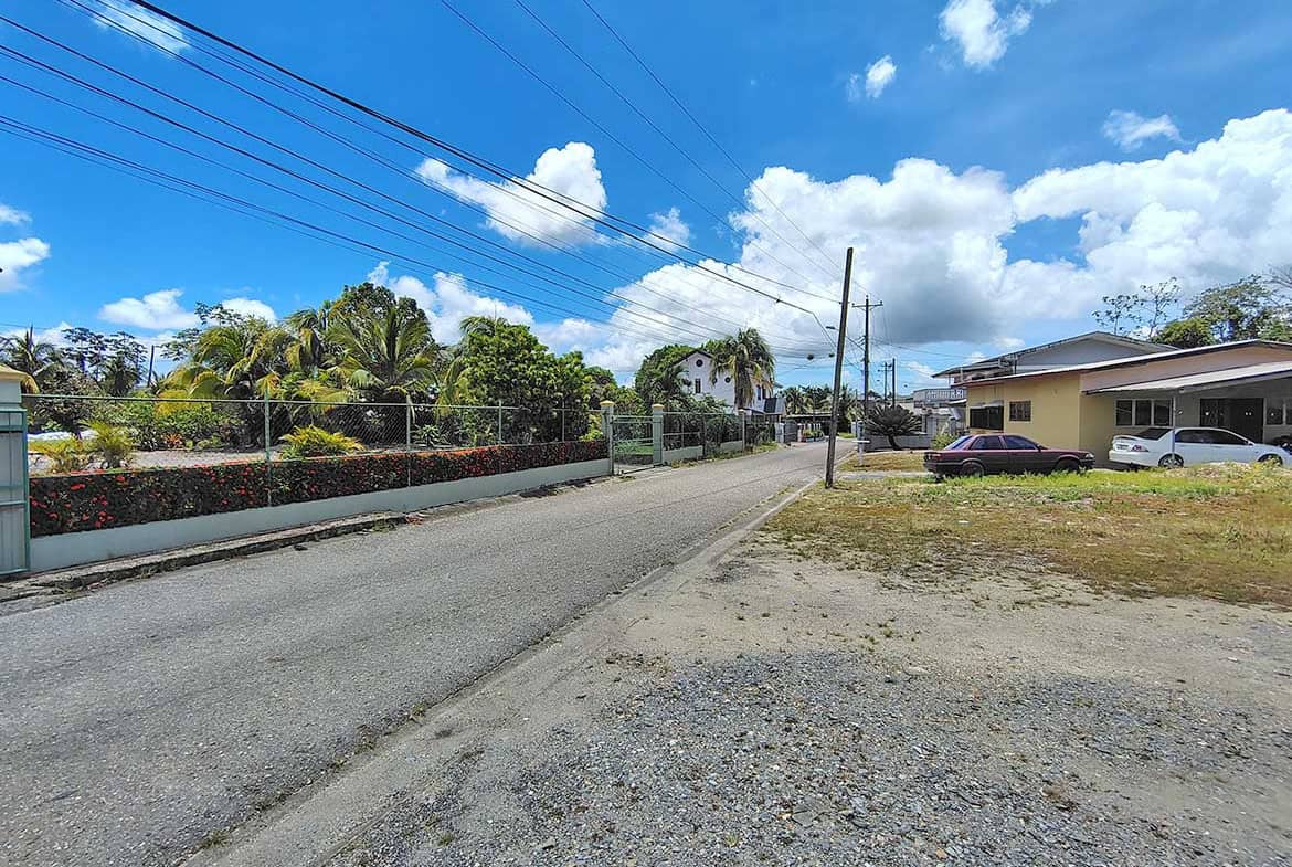Cornerstone- View of Ajim Baksh Road with houses and power lines under blue sky.