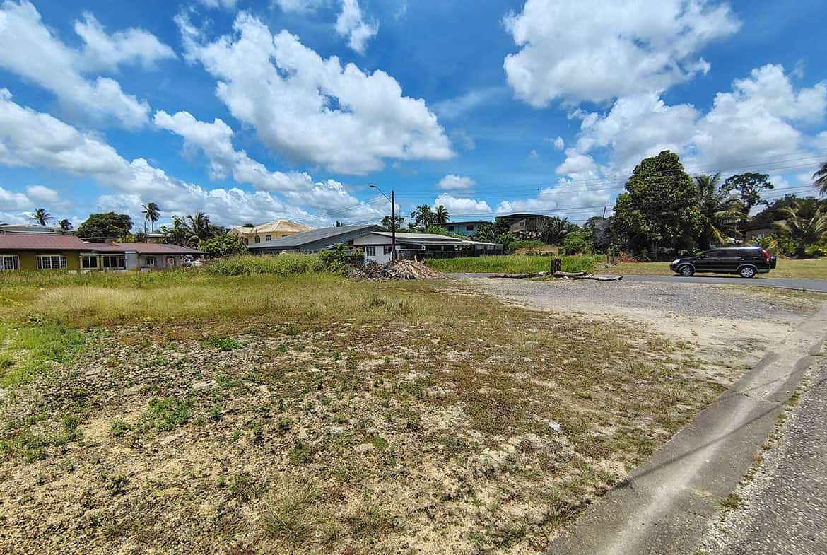 Cornerstone- Empty lot with grass and dirt on Off Ajim Baksh Road under blue sky.