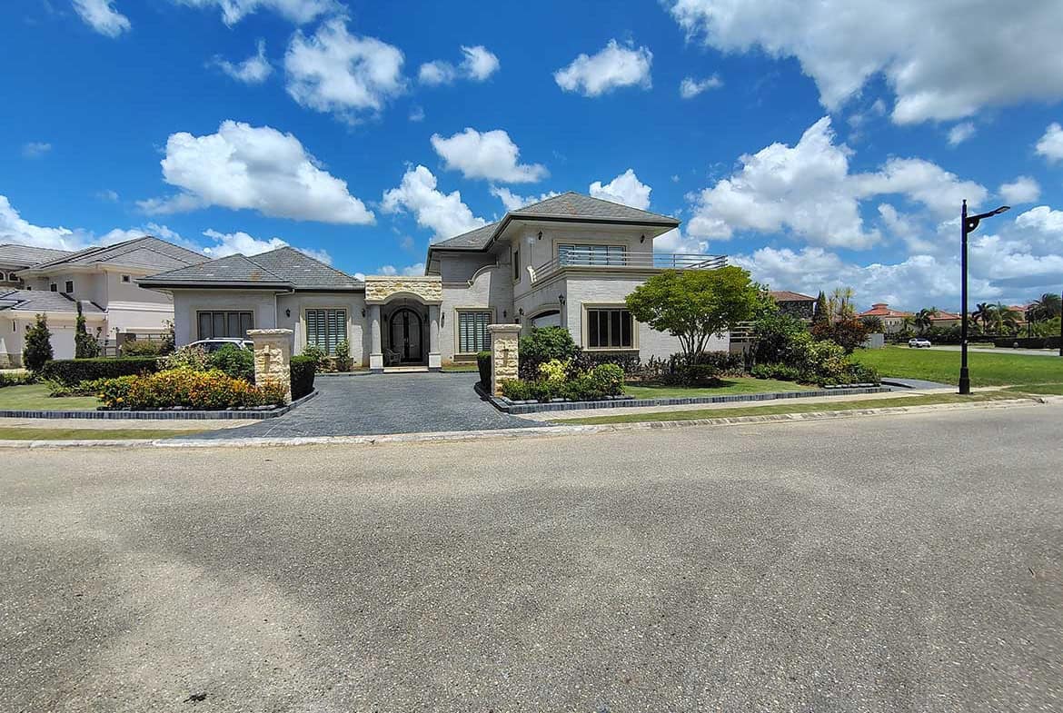Cornerstone- Elegant modern house with landscaped garden and blue sky.
