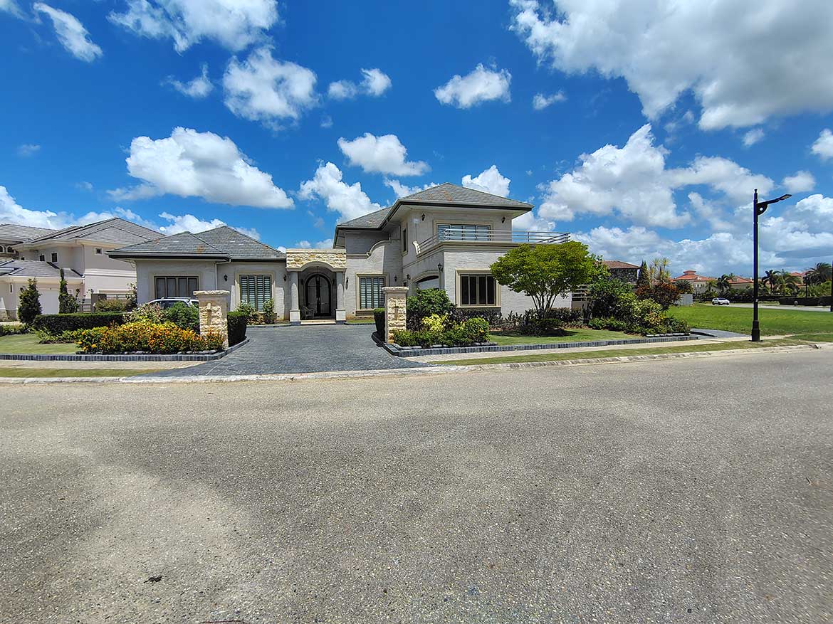 Cornerstone- Elegant modern house with landscaped garden and blue sky.