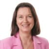 Cornerstone- Businesswoman smiling in pink blazer for real estate investment.