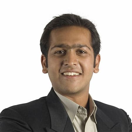 Cornerstone- Confident businessman in formal attire smiling at camera.