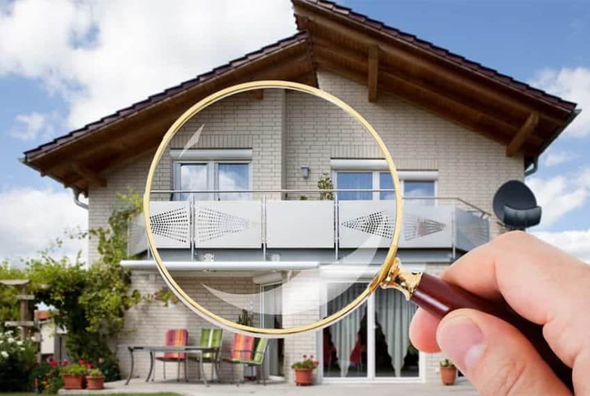 Cornerstone- Magnifying glass focusing on house balcony for real estate inspection.