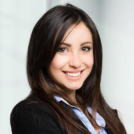 Cornerstone- Smiling woman in business attire with dark hair and blue shirt.
