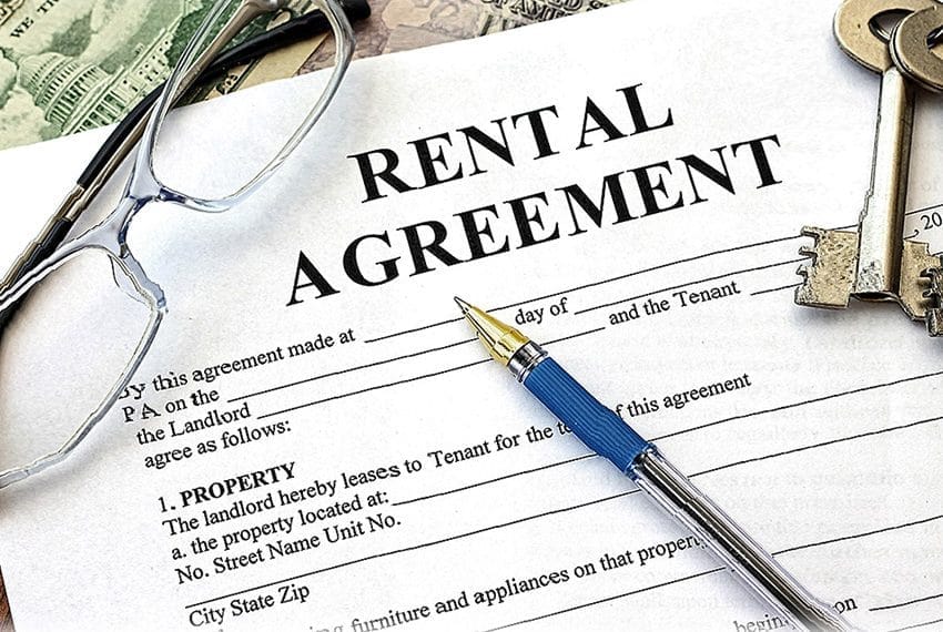 Cornerstone- Rental agreement form with pen, keys, and glasses on top.